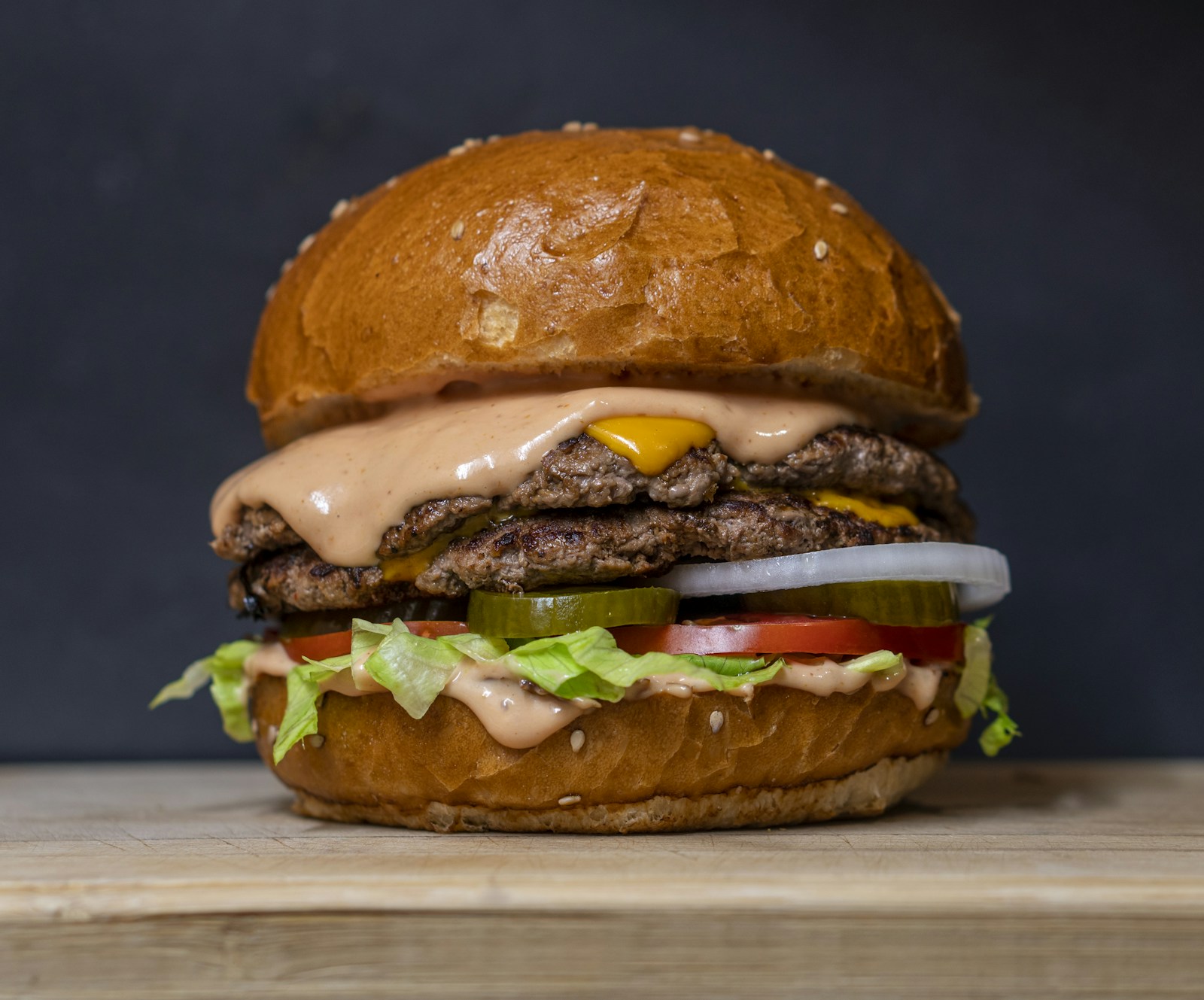 A freshly prepared burger with lettuce, tomato and cheese